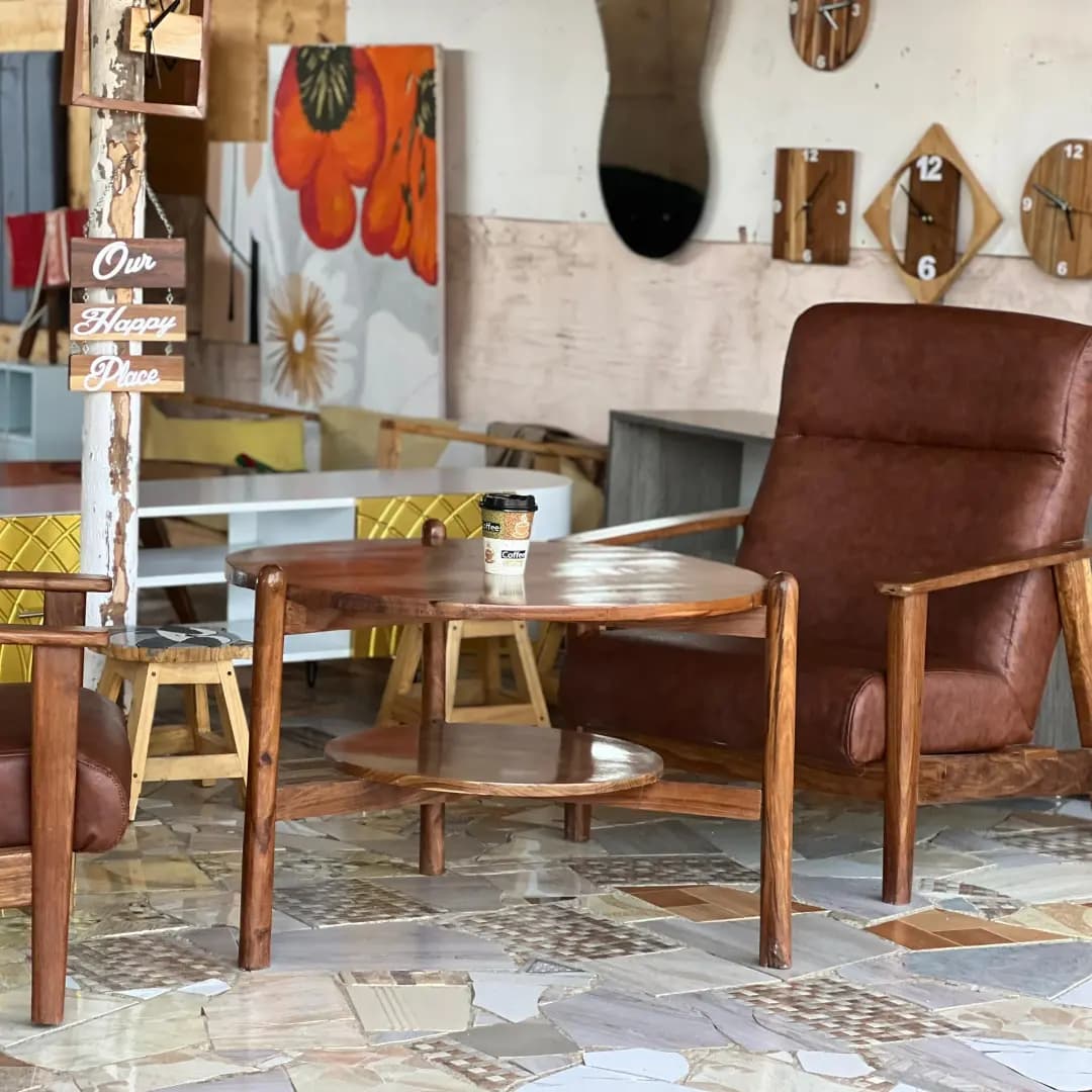 A leather-look armchair and round wooden coffee table in The Artist showroom, Dodoma.